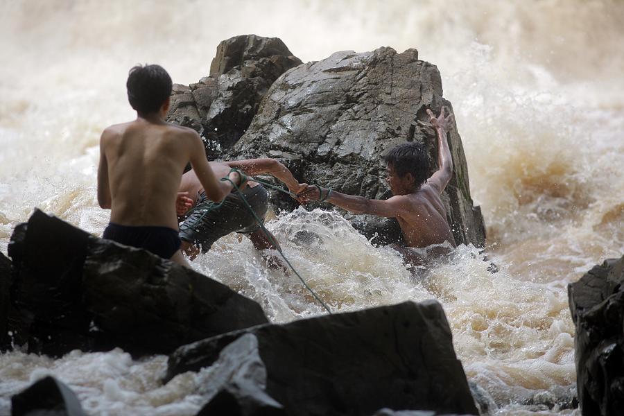 Laotian men fish on Mekong river island Photograph by Timothy Allen