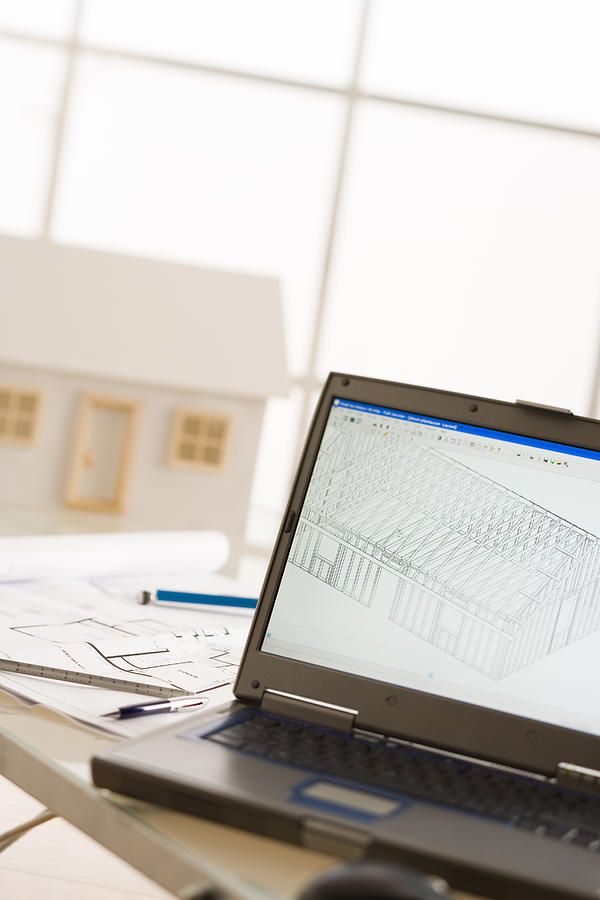 Laptop and blueprints Photograph by Comstock Images