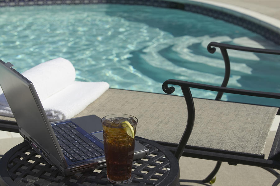 Laptop by pool Photograph by Comstock Images