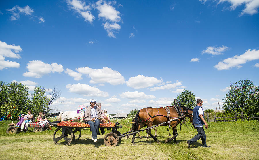 Large family groups riding on horses and carts in field, Rezh, Sverdlovsk Oblast, Russia Photograph by Aleksander Rubtsov