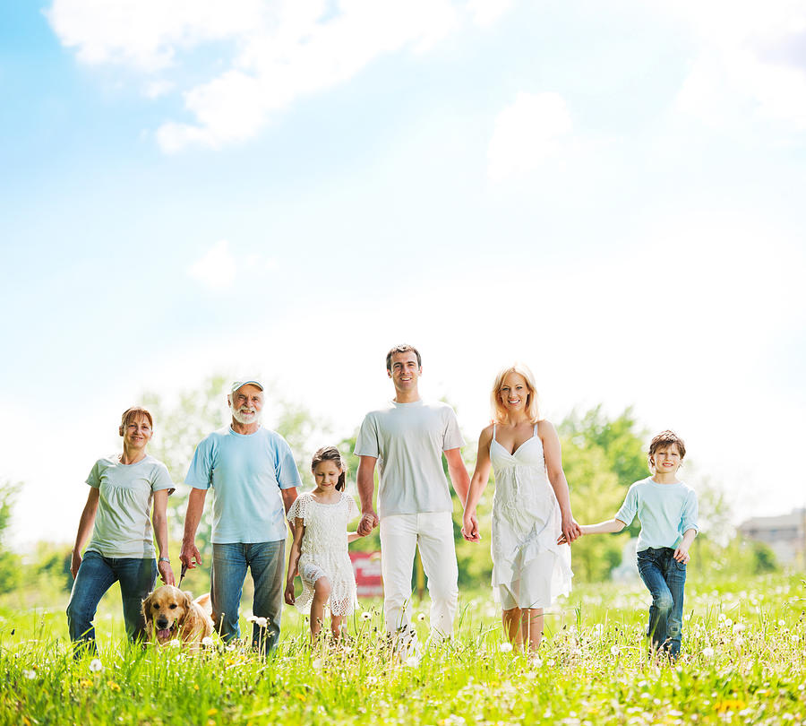 Large family with grandparents taking a walk in park. Photograph by Skynesher