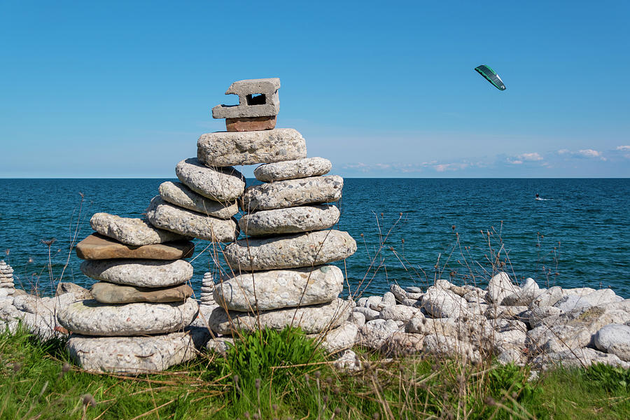 Large Inukshuk By A Lake With Parasailor Photograph