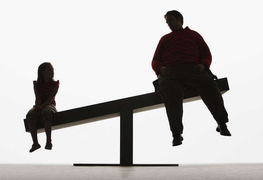 Large man and small girl on unbalanced plank Photograph by Martin Barraud