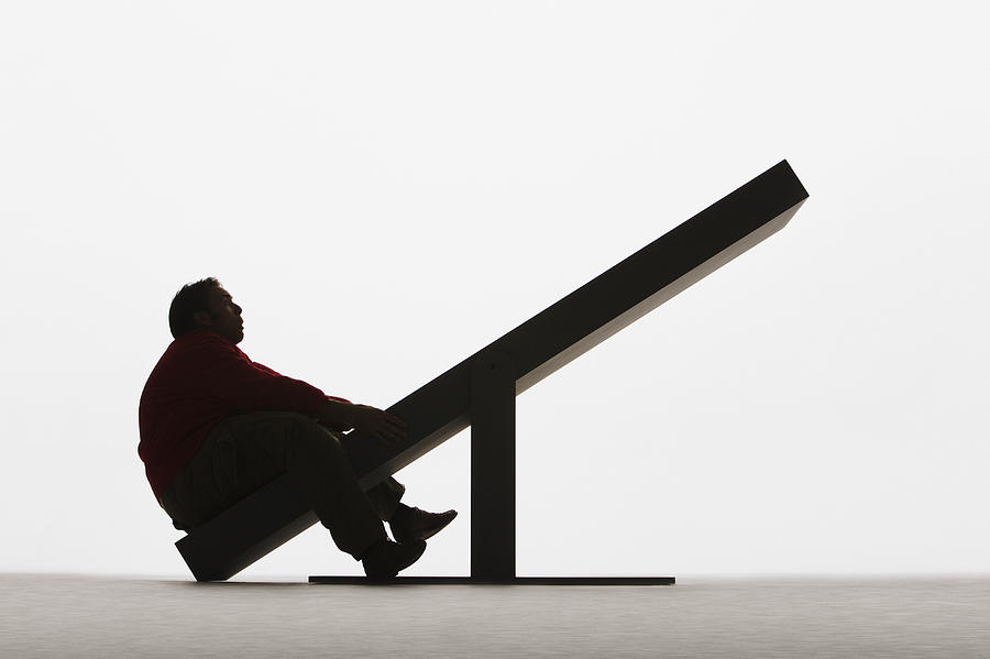 Large man on unbalanced plank Photograph by Martin Barraud