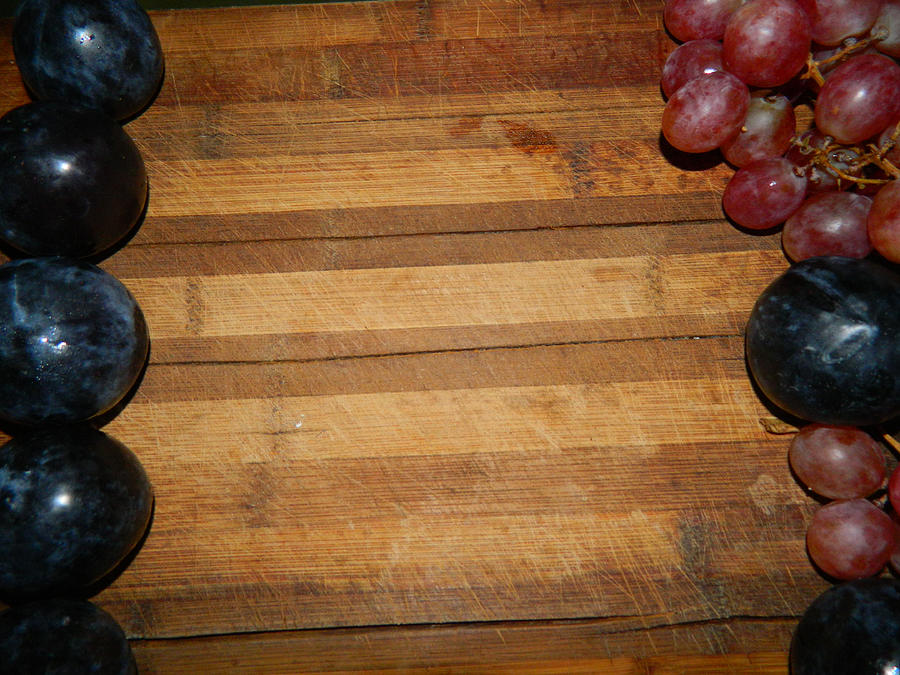 Large  plums and grapes on the sides of the wooden board Photograph by Papaika10