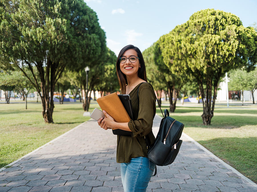 Latina college girl looking at the camera with a smile Photograph by Aldomurillo