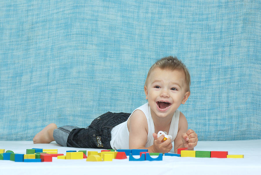 Laughing boy and wooden cubes Photograph by Alexandra Jursova