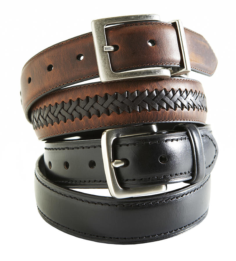 Leather belts on white background Photograph by Thomas Northcut