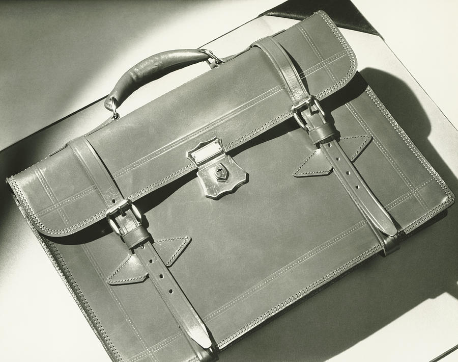 Leather briefcase lying on white blotter, (B&W), close-up Photograph by George Marks