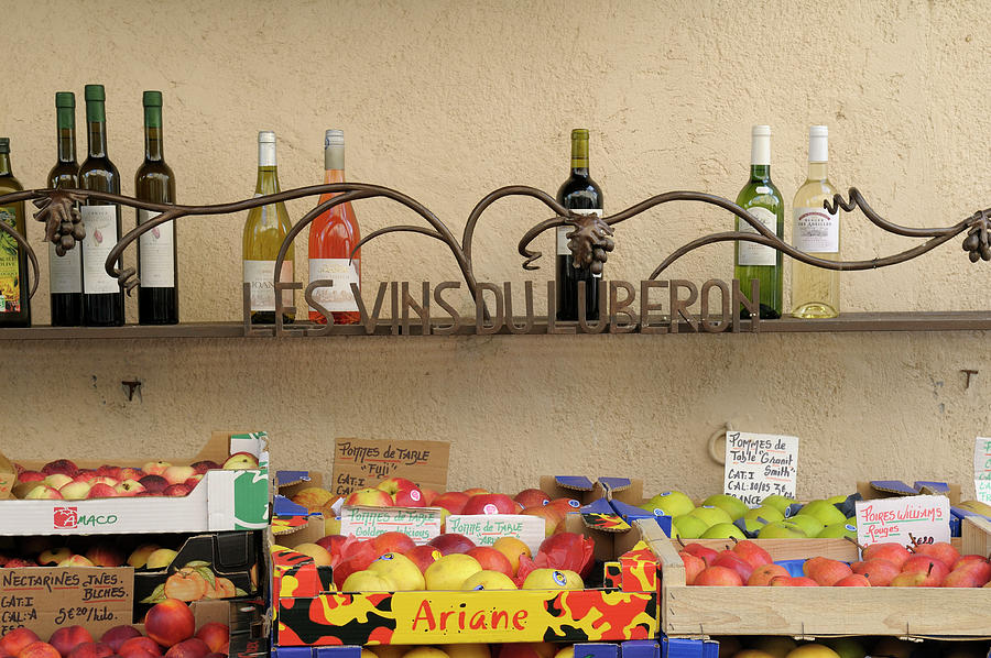 Les Vins Du Luberon store sign with wine bottles and fresh fruit, Lourmarin, France Photograph by Kevin Oke