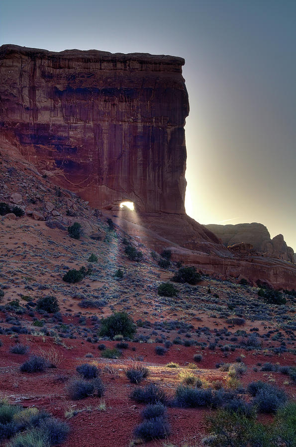 Let your Light Shine Through - Sun beaming through portal in Sheep Rock at Arches National Park Photograph by Peter Herman