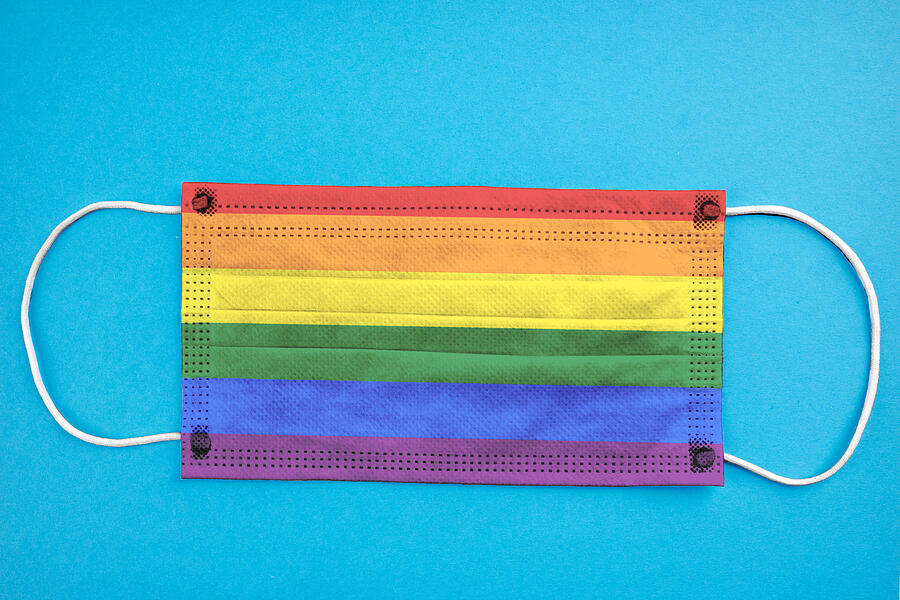 lGBT colored medical face mask isolated on blue background. coronavirus epidemic concept. safety supplies. rainbow symbol. Photograph by Andrii Atanov