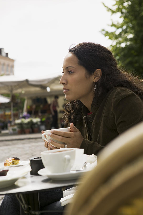 Lifestyle Portrait Of A Young Adult Woman As She Sits At An Outdoor Cafe Photograph by Photodisc