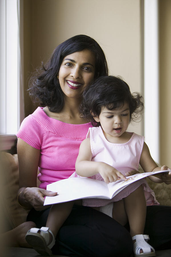 Lifestyle Shot Of An Adult Mother As She Reads To Her Young Daughter Photograph by Digital Vision