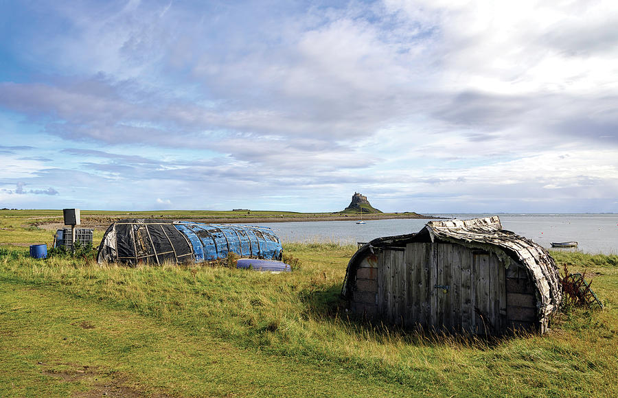Lindisfarne and the Boat store Photograph by Jon Jones