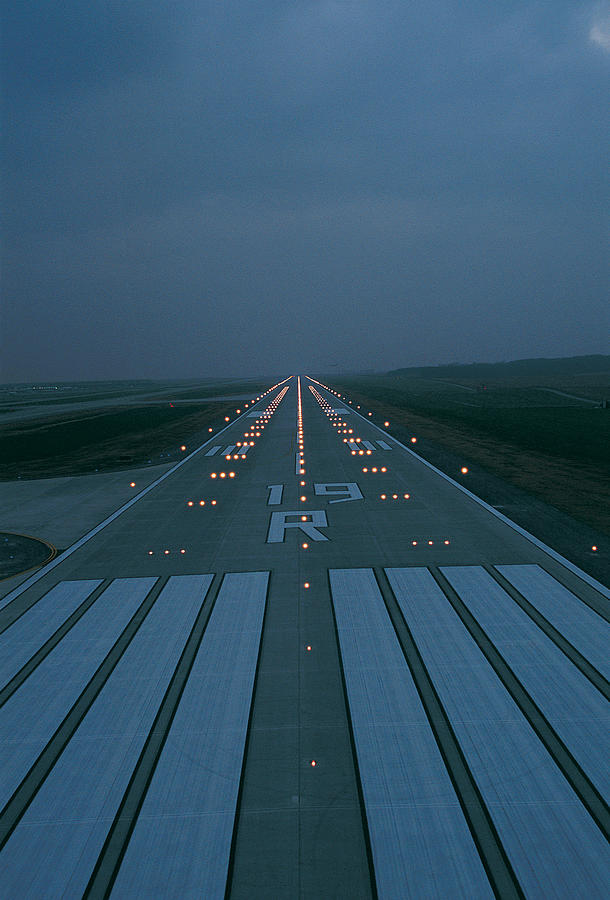 Lit flight runway at night Photograph by Digital Vision.