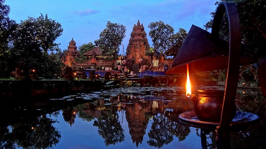 Lit Oil Lamp By Lake And Old Temple At Dusk Photograph by Joseph Jeanmart / EyeEm
