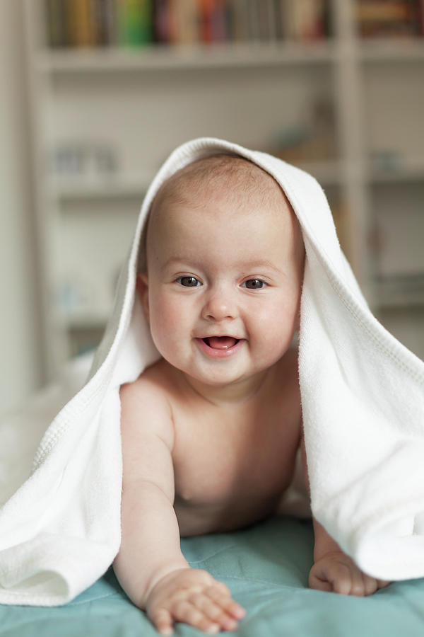 Little Baby Smiling, Laughing.cute Baby Lying On Her Tummy Over A White Towel. Photograph