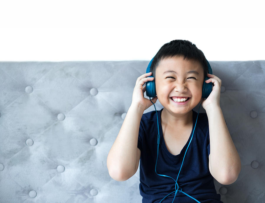 Little boy listening to music on bed at bedroom for relax Photograph by Suphansa Subruayying