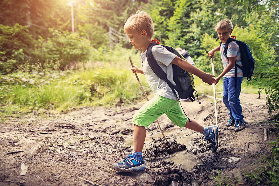 Little boys hiking on muddy path in forest Photograph by Imgorthand