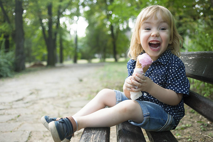 Little child eating ice cream in a park Photograph by Portishead1