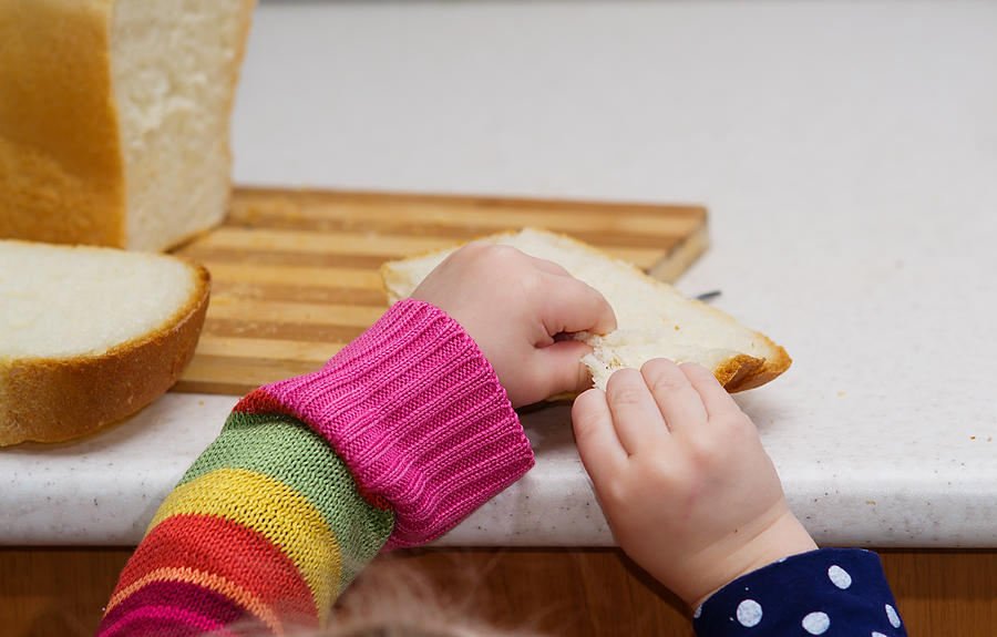 Little Girl Breaks Bread On A Close-up Table Photograph by Igor Borisenko