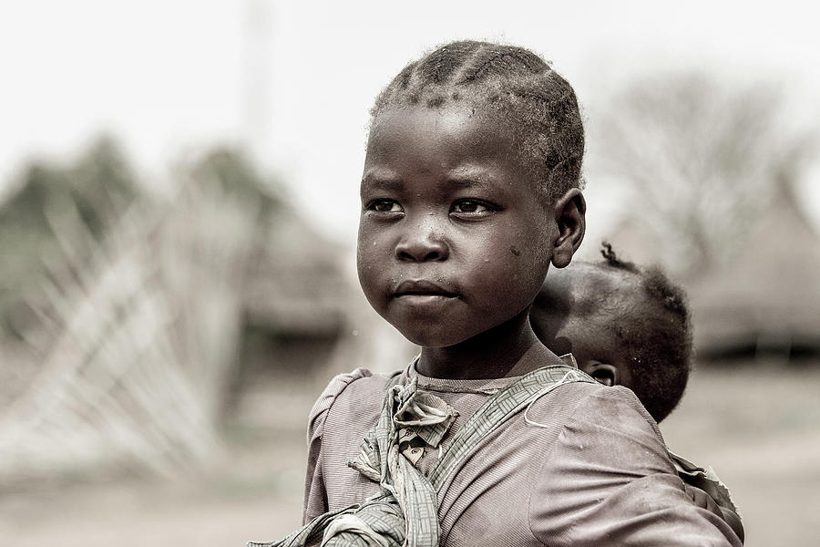 little girl carrying her sister, South Sudan Photograph by John ...