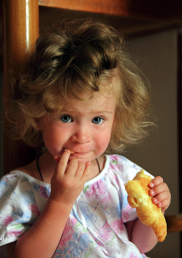 Little Girl Eating Croissant Photograph by Mikhail Kokhanchikov