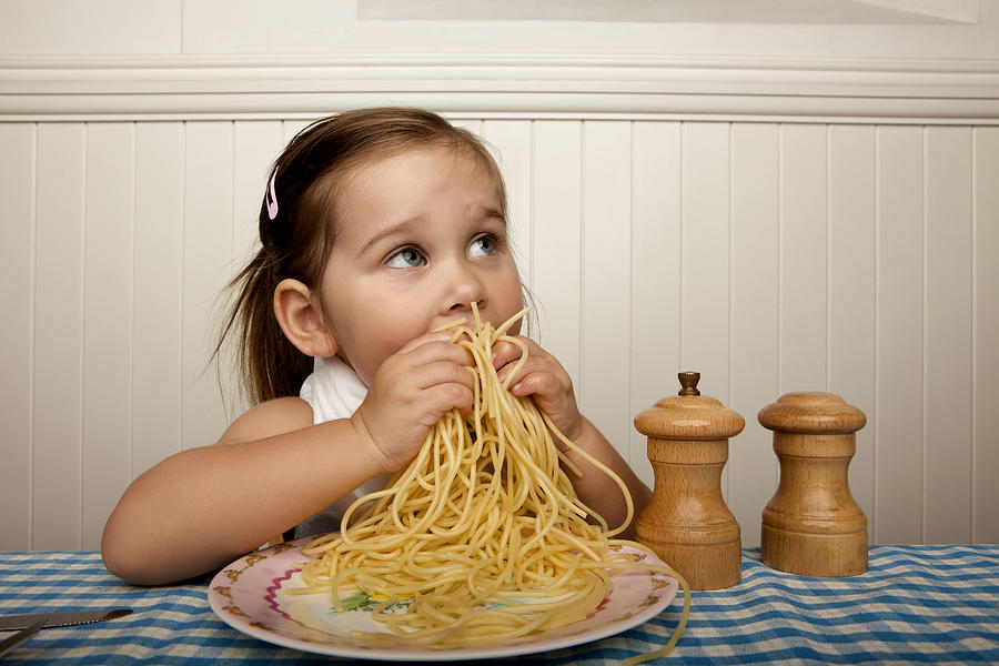 Little girl eating spaghetti with her hands Photograph by Hello World