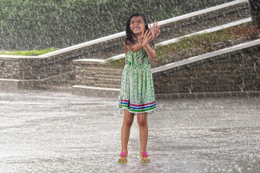 Little girl enjoying in the rain Photograph by IndiaPix/IndiaPicture