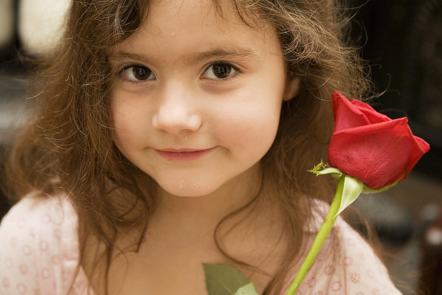 Little girl holding red rose Photograph by Mother Image