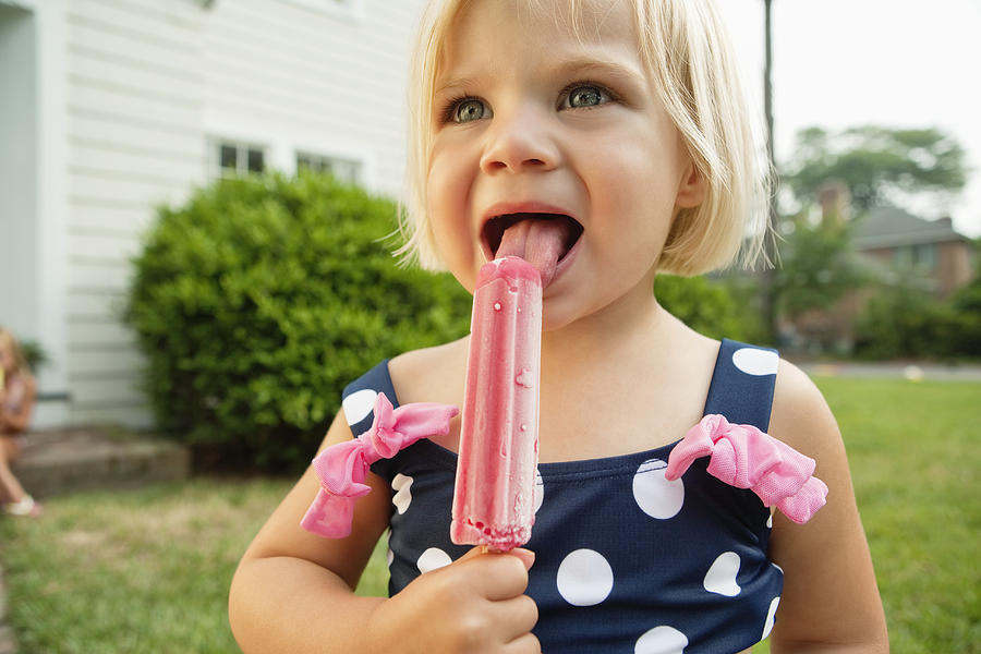 Little Girl In Bathing Suit With A Pink Popsicle  Photograph by Compassionate Eye Foundation/Alejandra Aguirre