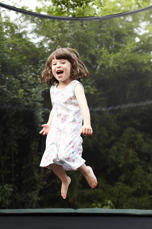 Little girl jumping on trampoline Photograph by Richard Drury