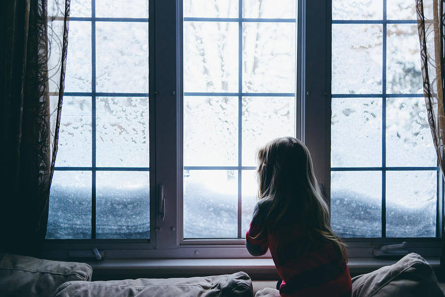 Little girl looking out window at snow Photograph by Photo by Francesca Russell