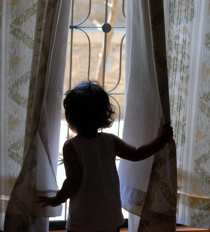 Little girl looking through window Photograph by Shilpa Harolikar