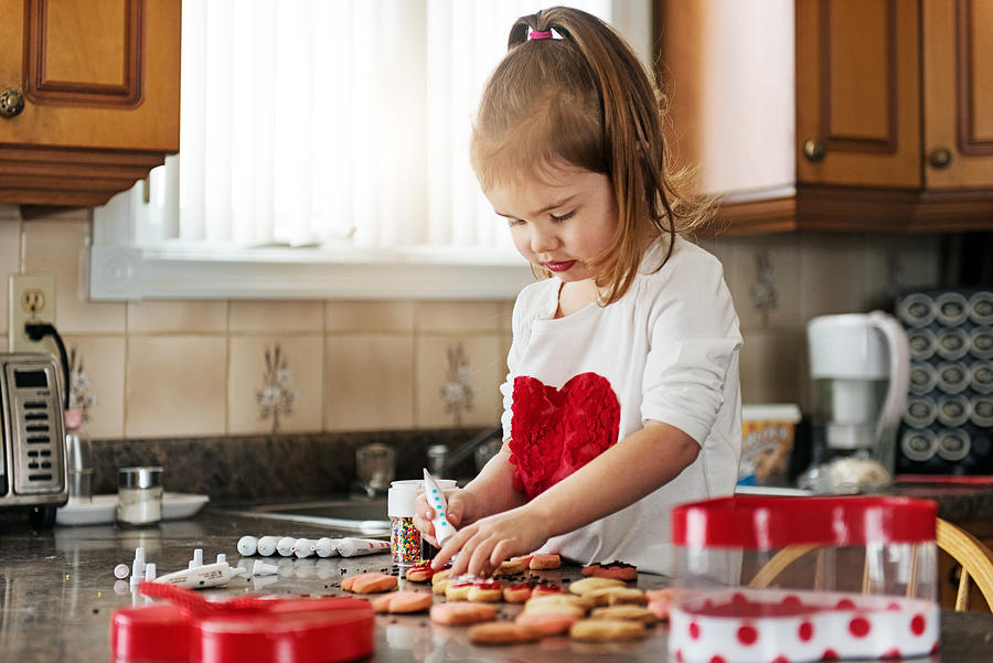 Little girl making valentine’s cookie Photograph by Lise Gagne