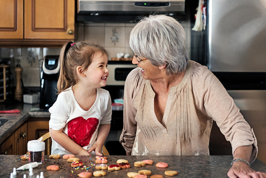 Little girl making valentine’s cookie with grandma Photograph by Lise Gagne
