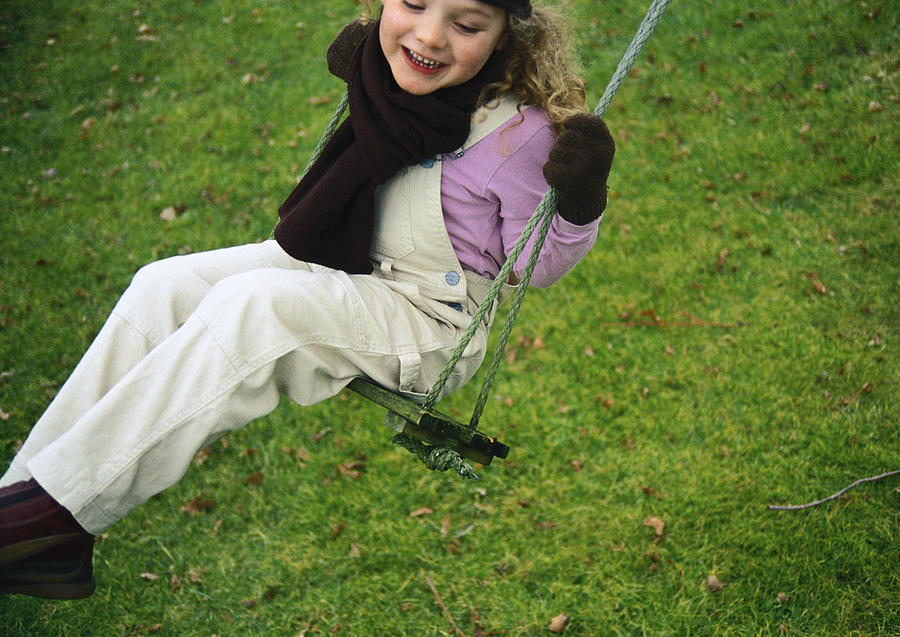 Little girl smiling on a swing. Photograph by Mieke Dalle