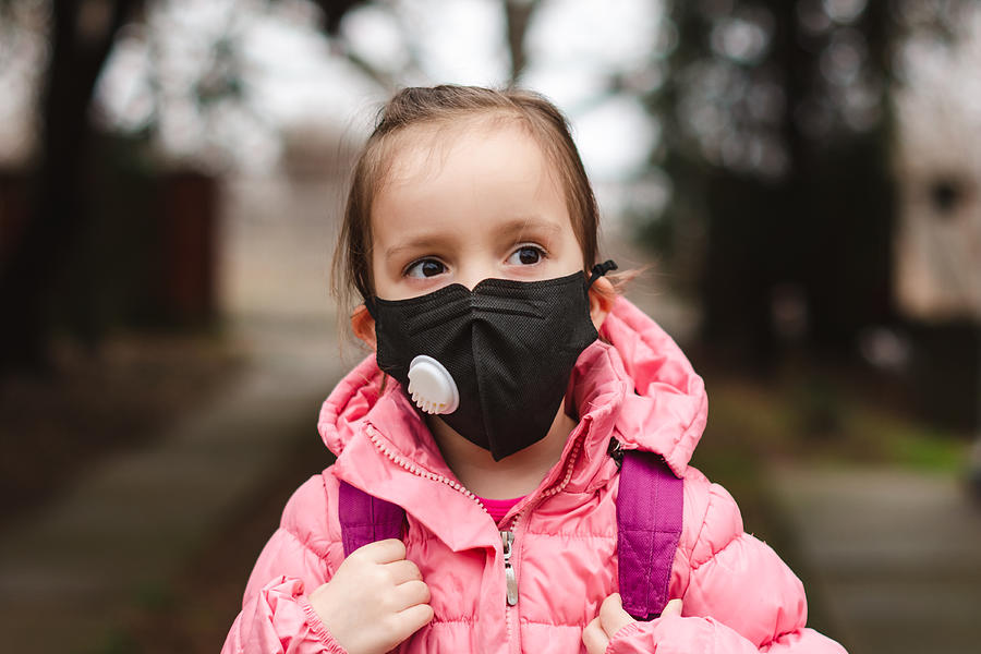 Little girl wearing pollution mask. Photograph by StockPlanets