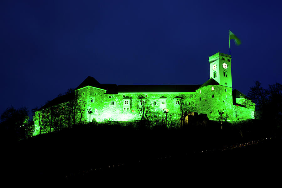 Ljubljana Castle lit up green at night to celebrate its status a Photograph by Ian Middleton