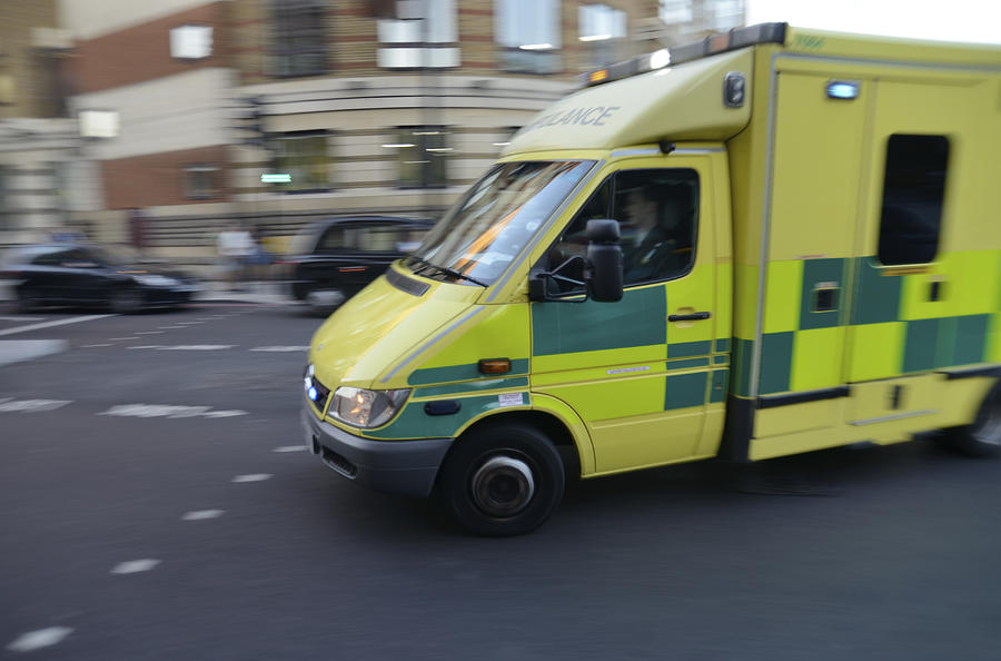 London ambulance on signal turning street corner Photograph by Piccell