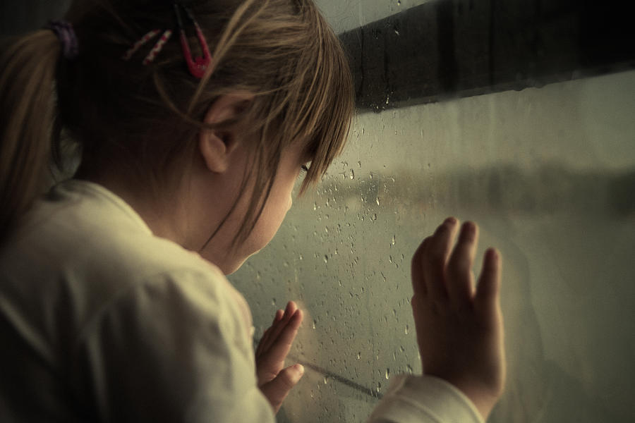 Lonely child looking through window Photograph by IvanJekic