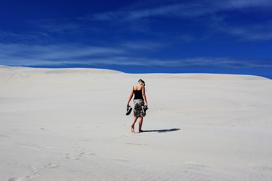 Lonely girl walking in sand dunes / desert Photograph by Pejft