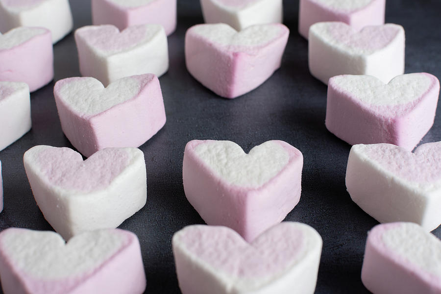 Love heart marshmallows lined up with one missing side view Photograph by Scott Lyons