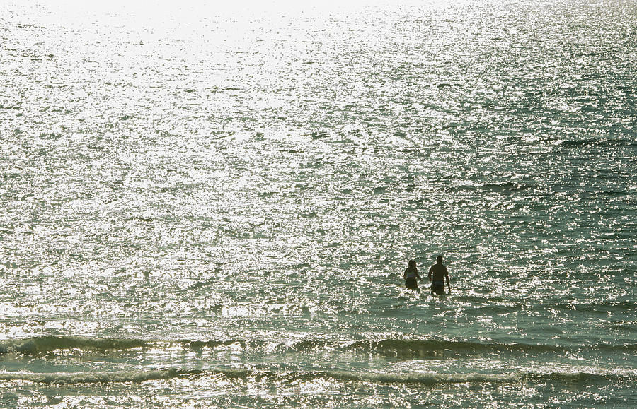 Loving couple entering and enjoying the sea at sunset Photograph by Michalakis Ppalis