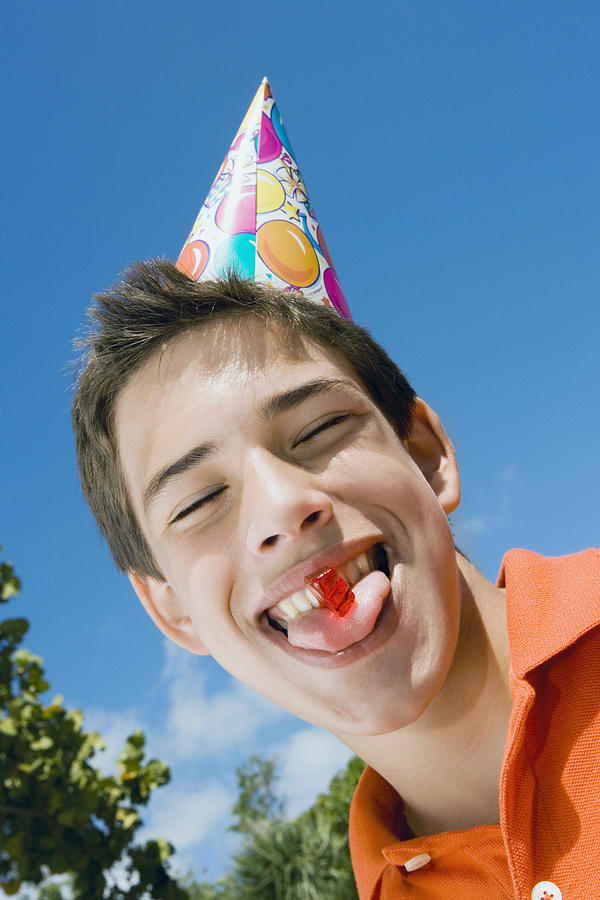 Low angle view of a boy eating a candy Photograph by Glowimages