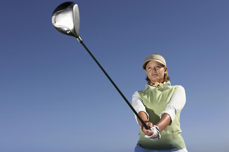Low Angle View of a Woman Swinging a Golf Club Photograph by John Cumming