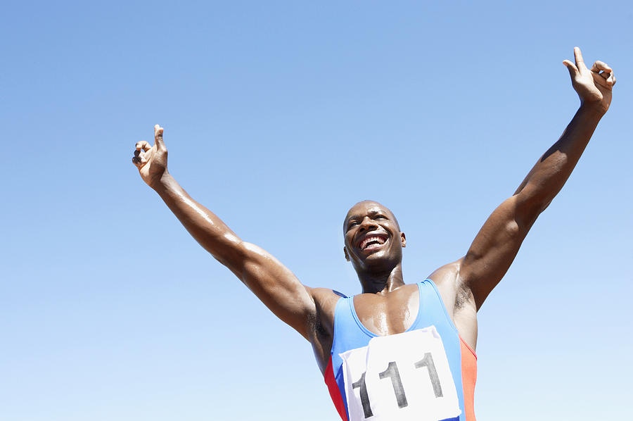 Low Angle View of an Athlete Celebrating With His Arms Upstretched Photograph by John Cumming