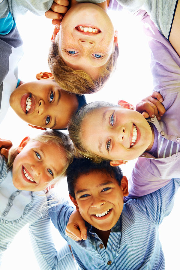 Low angle view of cheerful children huddling together Photograph by GlobalStock