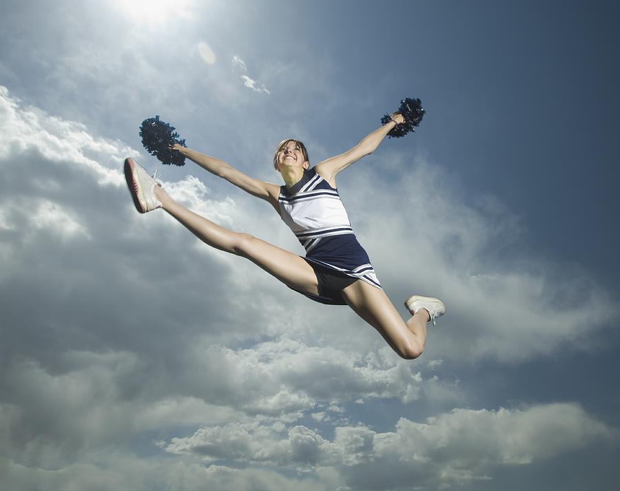 Low angle view of cheerleader jumping Photograph by Erik Isakson